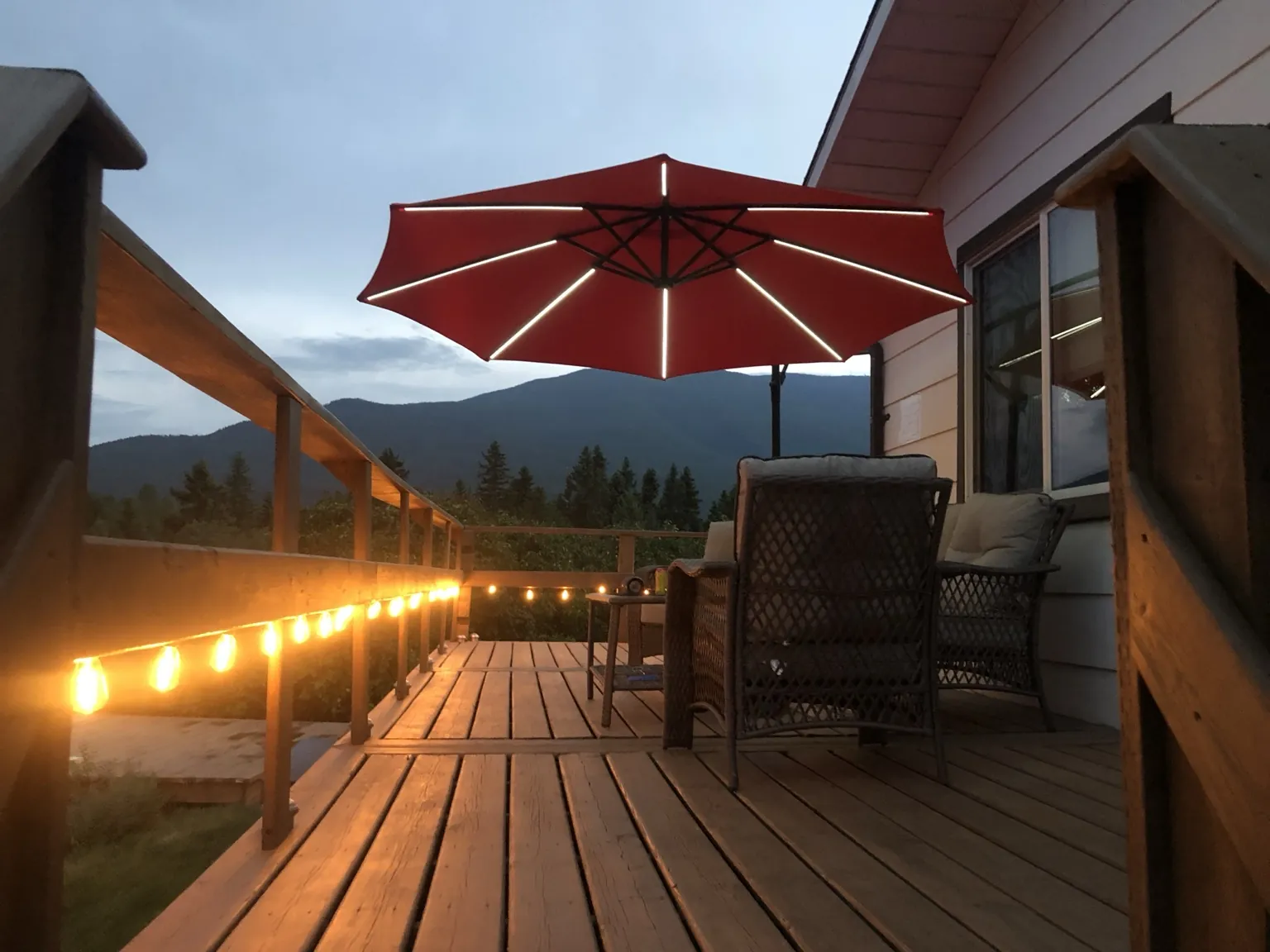 Deck at dusk with lights and mountain view